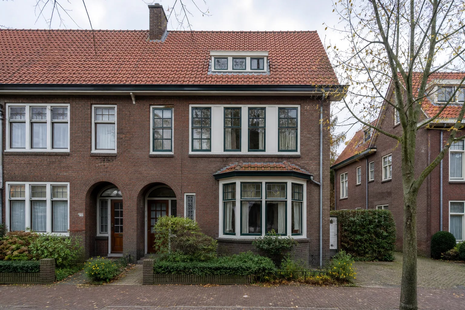 Jaren-30-woning in baksteen met erker, verticale raamverdeling en karakteristieke kozijnen