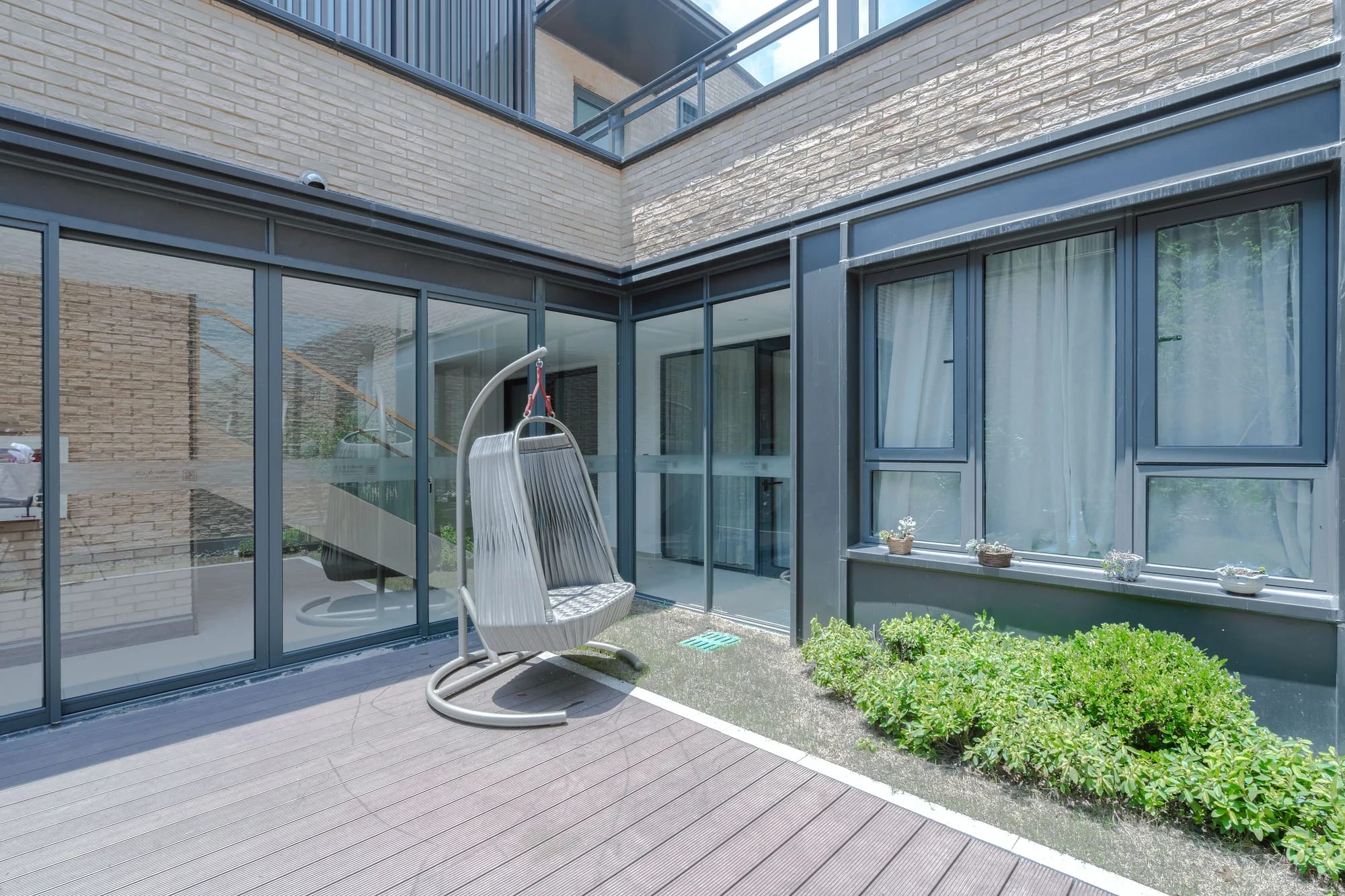 Achtergevel met nieuwe deuren en kozijnen naar een terras, na uitvoering van de renovatie