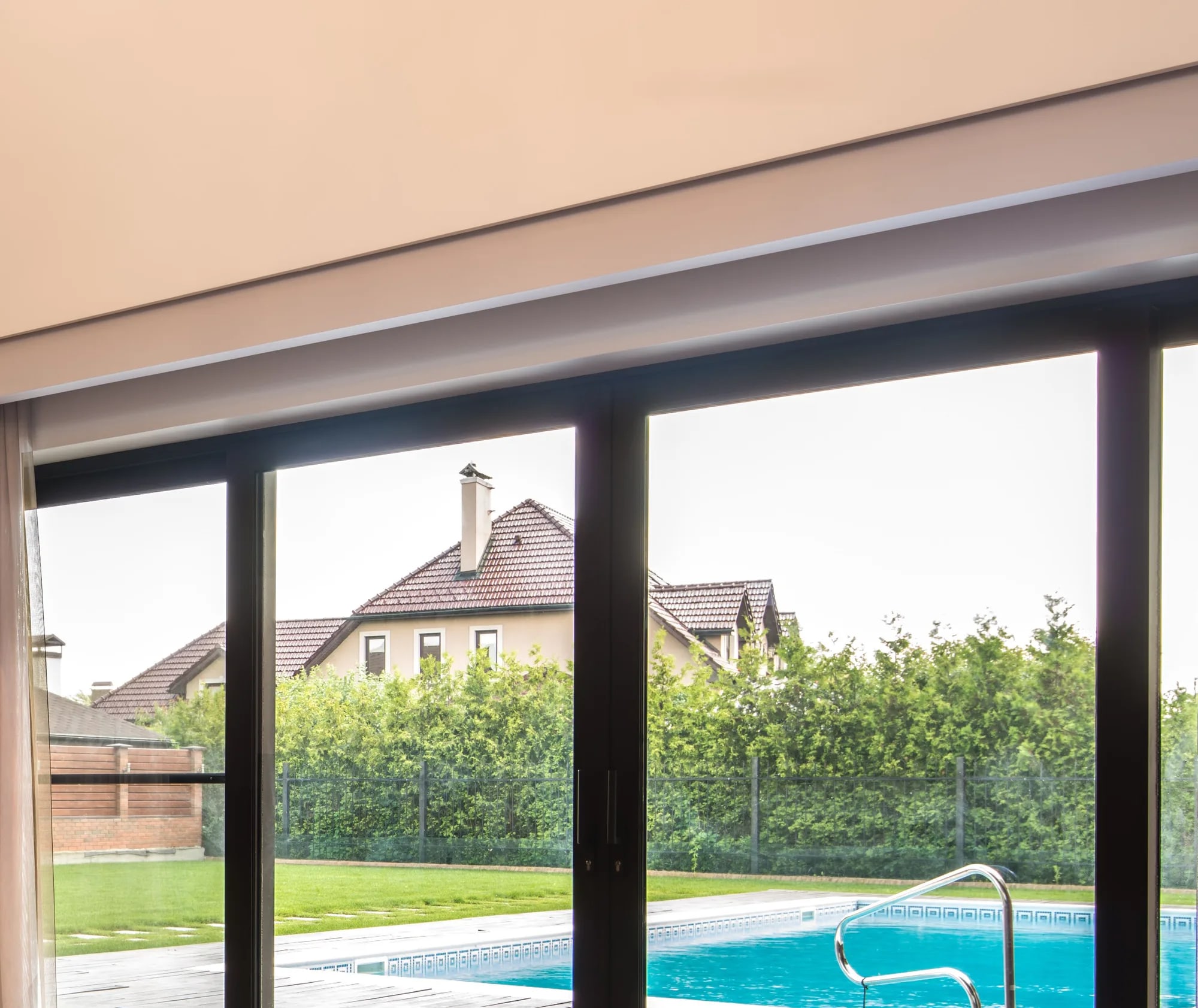 Slanke antraciet aluminium puien met grote glasvlakken vanuit de woonkamer naar terras en tuin